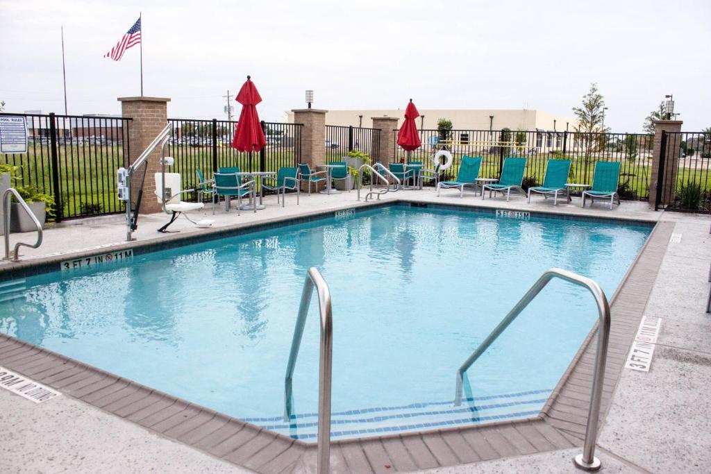 una piscina en un hotel con sillas en TownePlace Suites by Marriott Beaumont Port Arthur, en Port Arthur