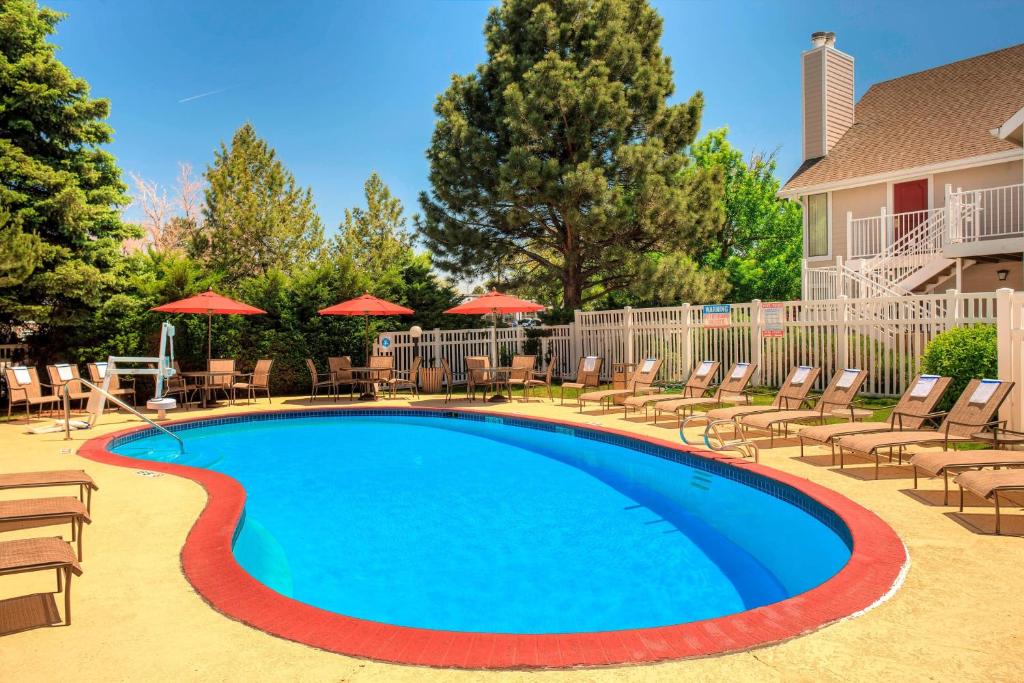 - une piscine avec des chaises longues et des parasols dans l'établissement Residence Inn Denver Tech Center, à Greenwood Village