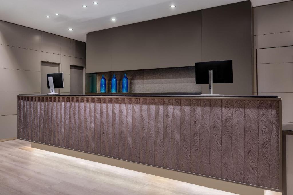 a lobby with a reception desk with blue bottles at AC Hotel Sevilla Fórum by Marriott in Seville