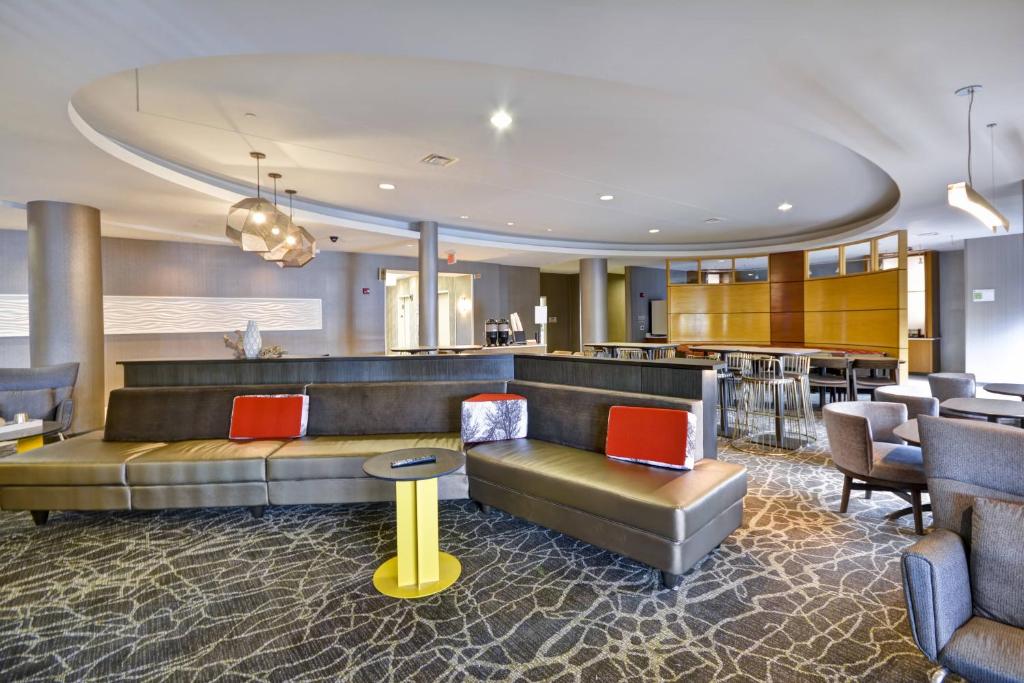 a hotel lobby with a couch and a bar at SpringHill Suites Lexington Near the University of Kentucky in Lexington