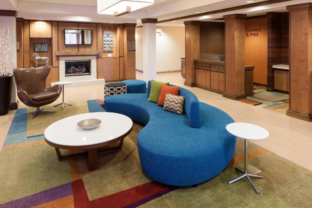 a living room with a blue couch and a table at Fairfield by Marriott Ruston in Ruston