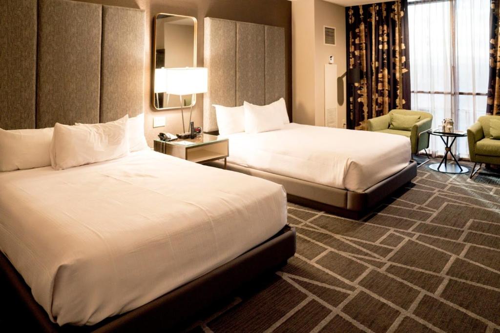 a hotel room with two beds and a chair at Strip Las Vegas Unit by Luxor and T Mobile arena area in Las Vegas
