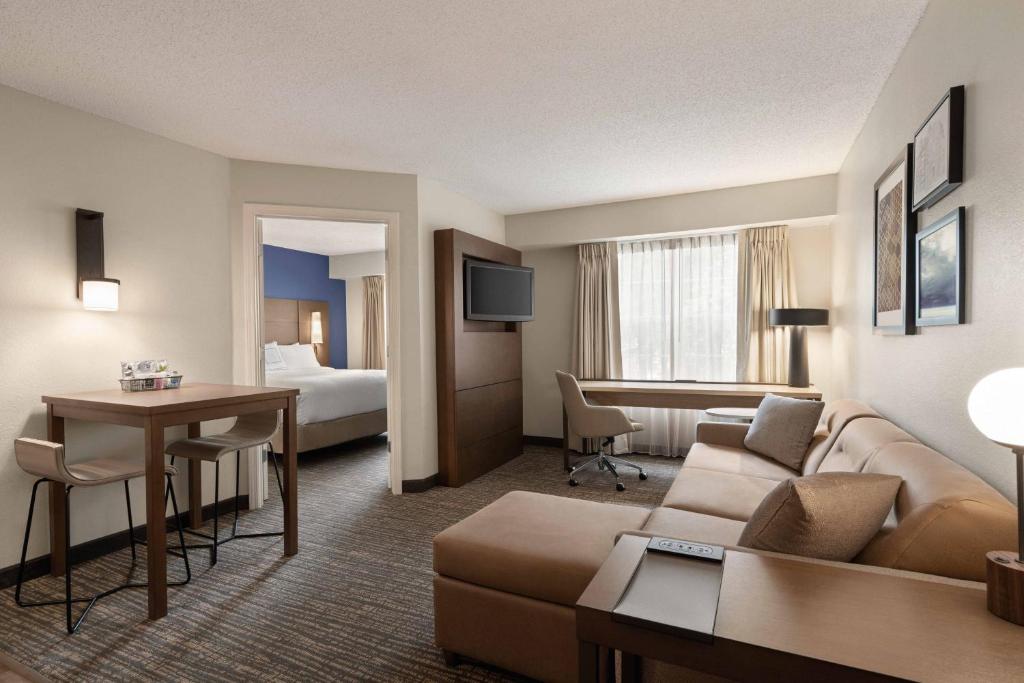 um quarto de hotel com um sofá, uma mesa e uma cama em Residence Inn Atlanta Gwinnett Place em Duluth