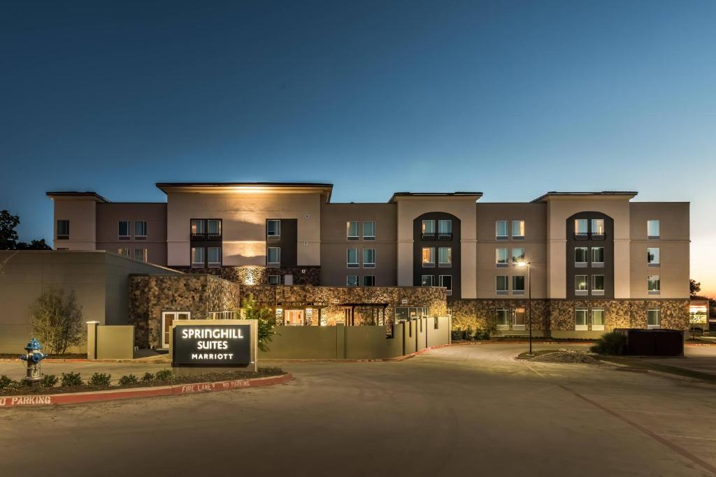 um grande edifício com uma placa em frente em SpringHill Suites by Marriott Dallas Rockwall em Rockwall