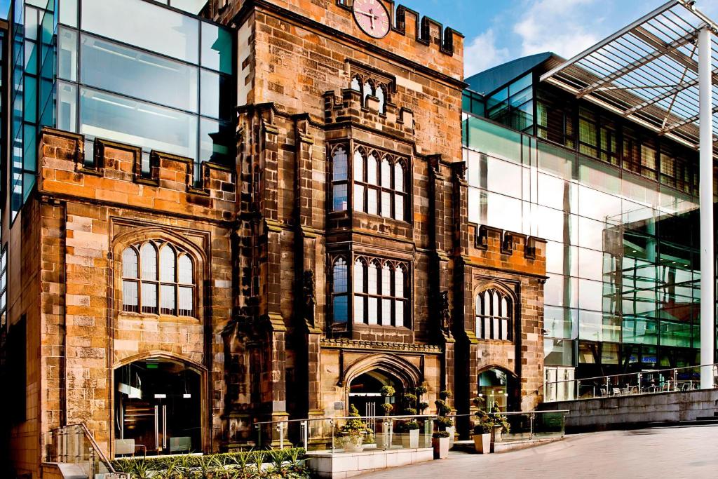 a large brick building with a clock on it at The Glasshouse, Autograph Collection in Edinburgh