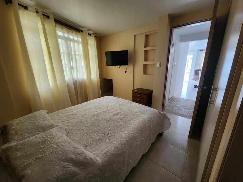 - une chambre avec un lit et une porte coulissante en verre dans l'établissement Apartamento completo en el sur de Buga, à Buga