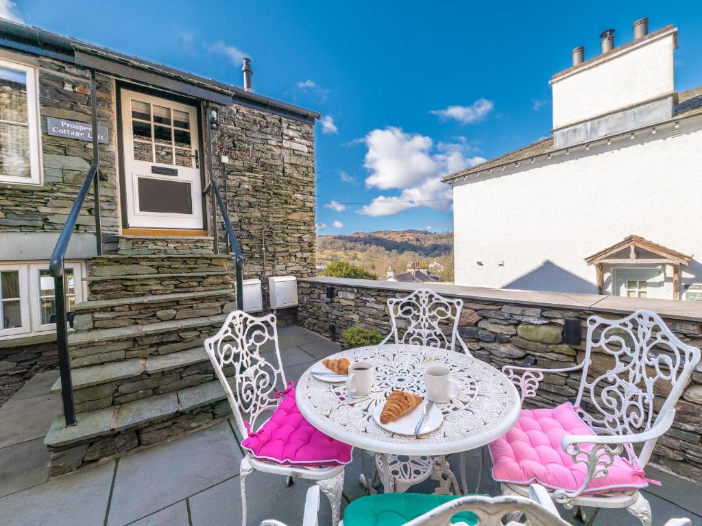 a table and chairs on the balcony of a cottage at Prospect Cottage Loft in Ambleside