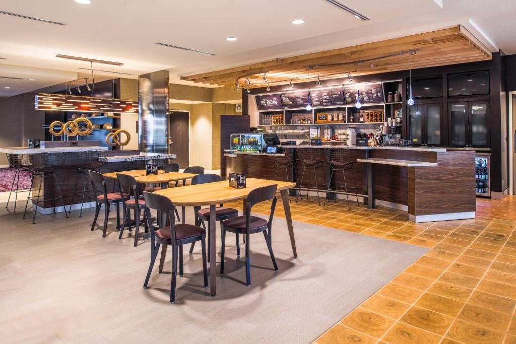 a bar with wooden tables and chairs in a restaurant at Courtyard by Marriott Detroit Farmington in Farmington Hills