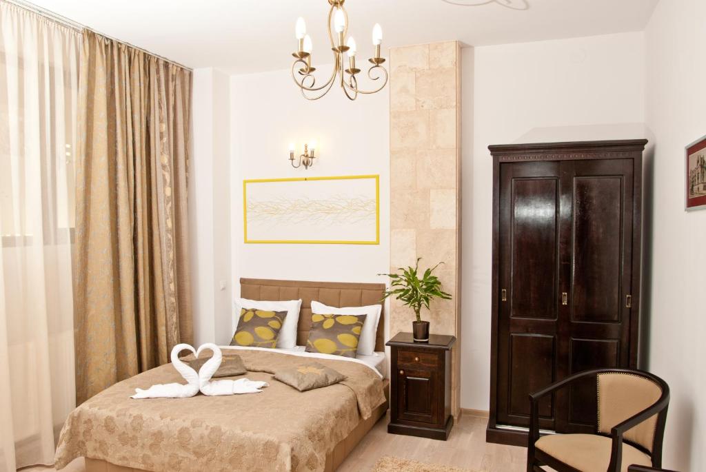 a bedroom with a bed and a chair in it at Hotel Belleville in Iaşi
