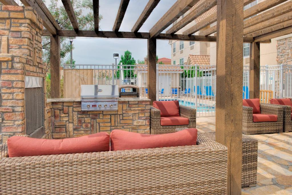 an outdoor patio with wicker chairs and a grill at TownePlace Suites by Marriott Las Cruces in Las Cruces