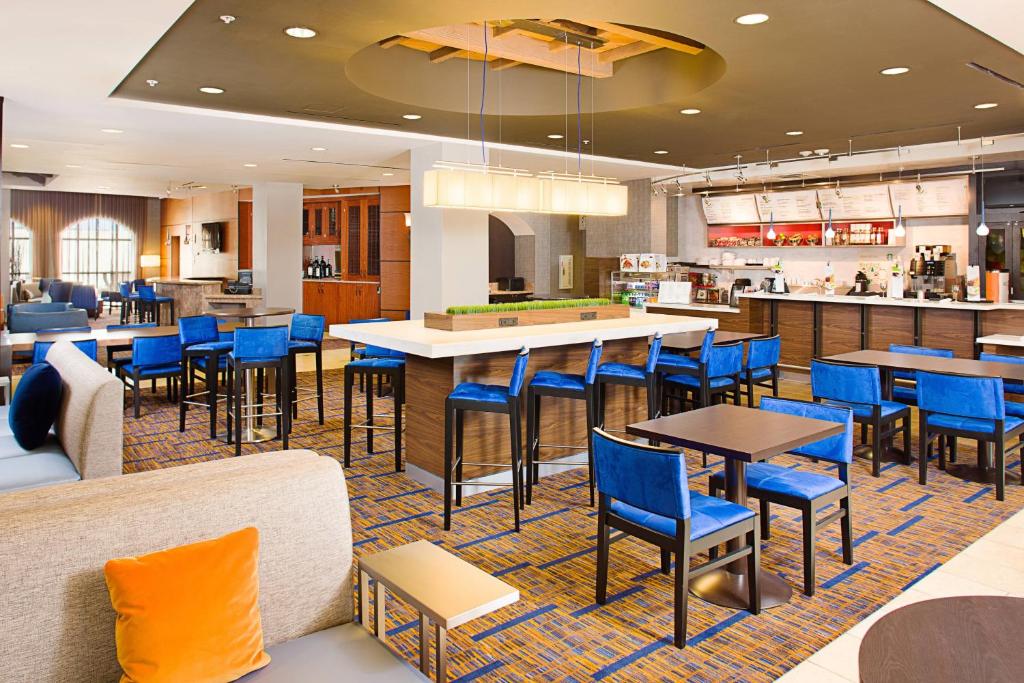 a restaurant with blue chairs and tables and a bar at Courtyard by Marriott Paso Robles in Paso Robles