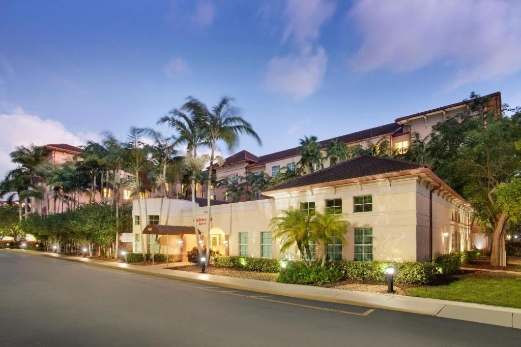 a building with palm trees in front of a street at Residence Inn Fort Lauderdale SW/Miramar in Miramar