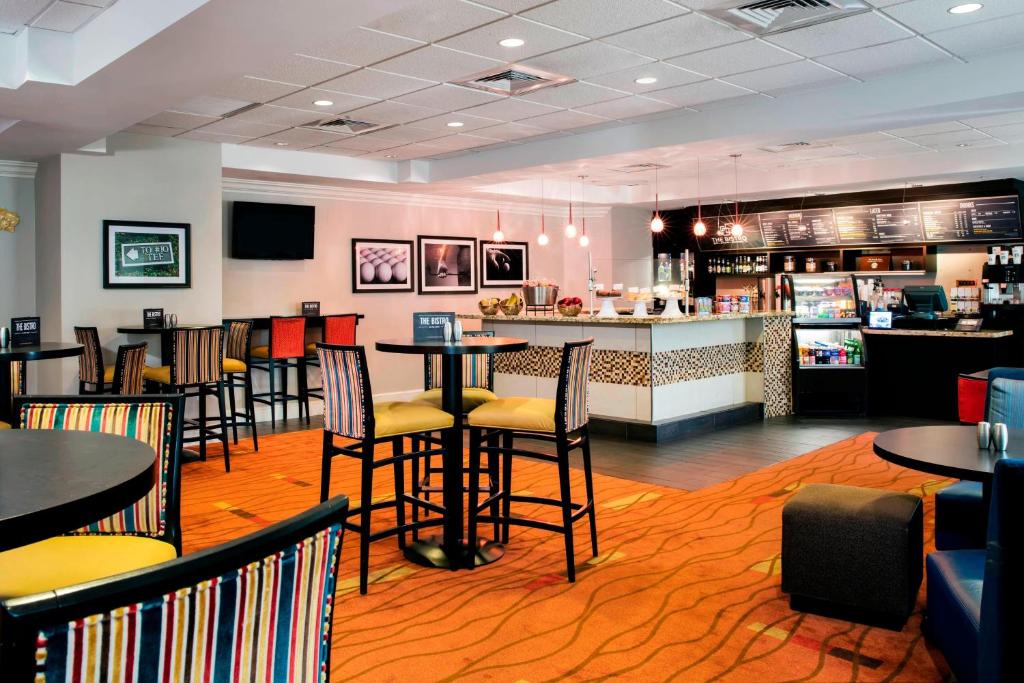 a restaurant with tables and chairs and a bar at Courtyard by Marriott Myrtle Beach Barefoot Landing in Myrtle Beach