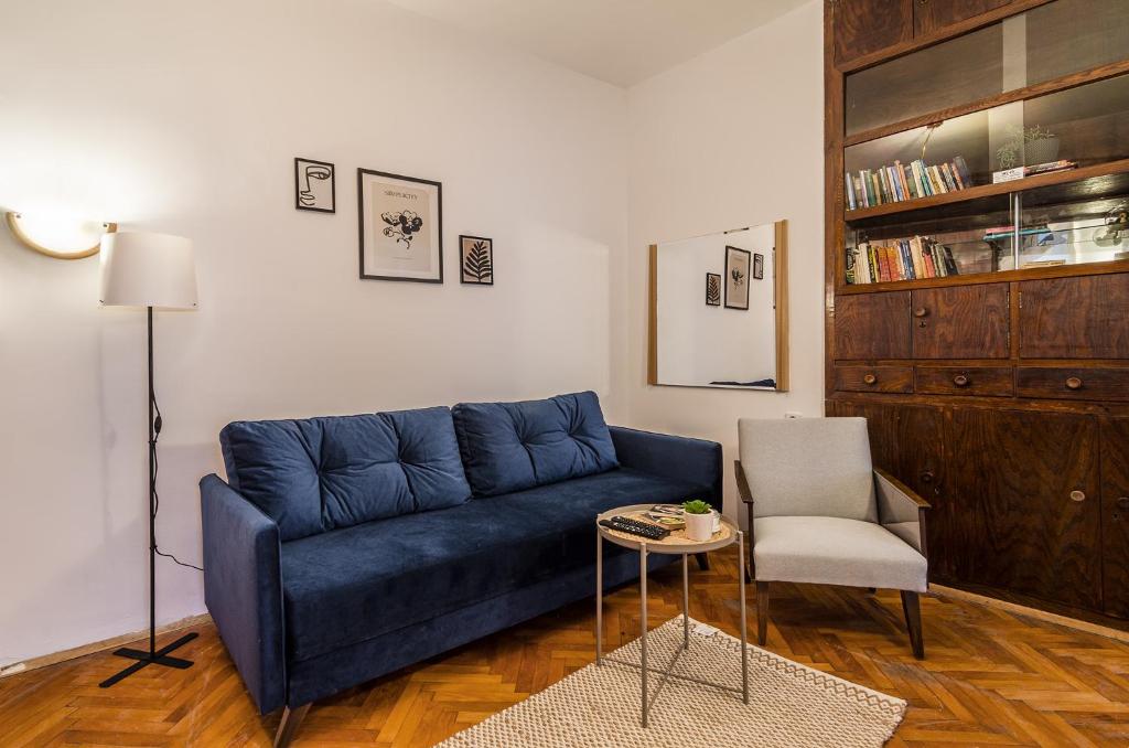 a living room with a blue couch and a chair at Lovely Art apartment - Victory in Varna City