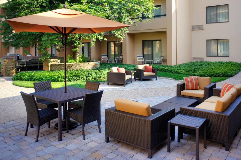un patio con mesas, sillas y una sombrilla en Courtyard by Marriott Lexington North, en Lexington