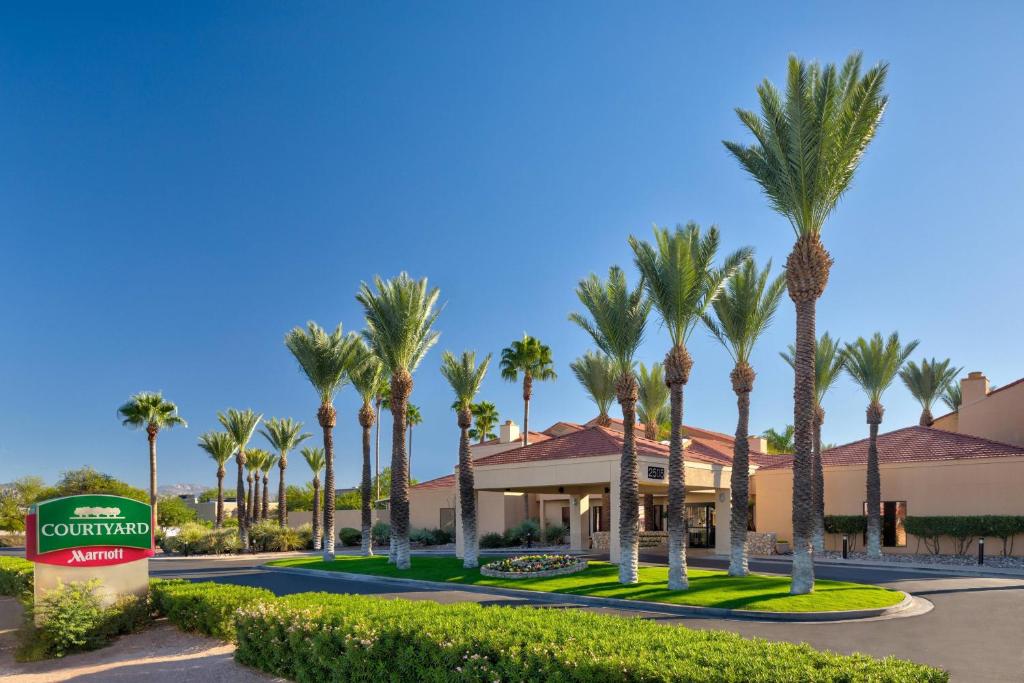 a resort with palm trees and a sign at Courtyard Tucson Airport in Tucson