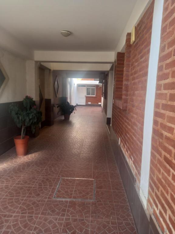 pasillo con pared de ladrillo y suelo de ladrillo en Depa9 en San Salvador de Jujuy