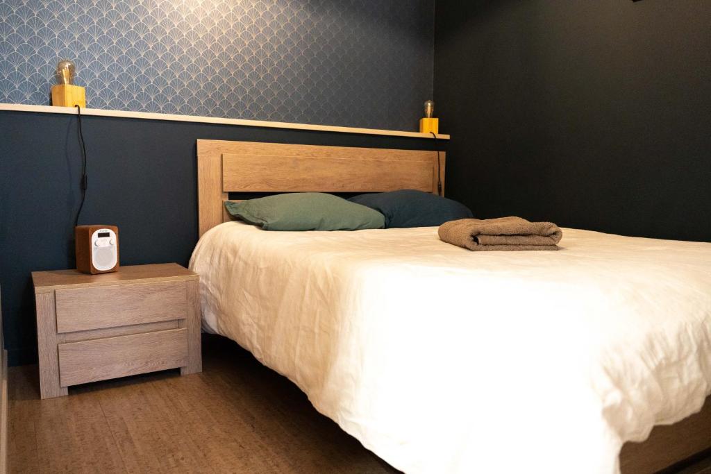 a bedroom with a bed and a clock on a night stand at Studio Ropartz au pied du métro in Rennes