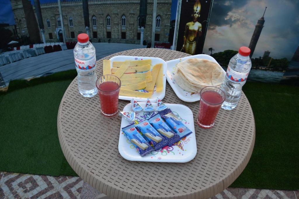 un tavolo con un piatto di cibo e bottiglie d'acqua di Aladdin pyramids City 2 a Il Cairo