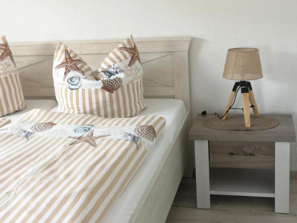 ein Schlafzimmer mit 2 Betten und einem Tisch mit einer Lampe in der Unterkunft Ferienwohnung Joanna in Norddeich