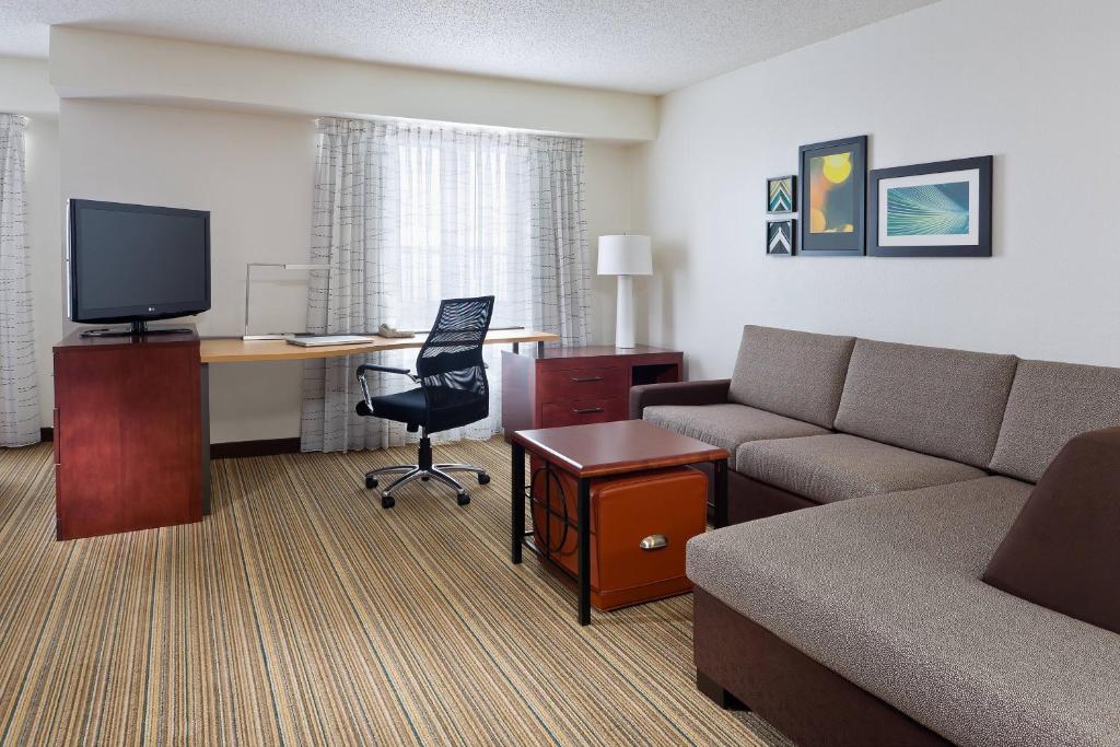 une chambre d'hôtel avec un canapé et un bureau avec un ordinateur dans l'établissement Residence Inn Youngstown Boardman/Poland, à Poland