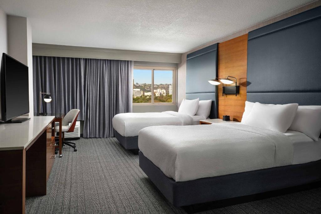 a hotel room with two beds and a television at Courtyard Los Angeles Century City/Beverly Hills in Los Angeles