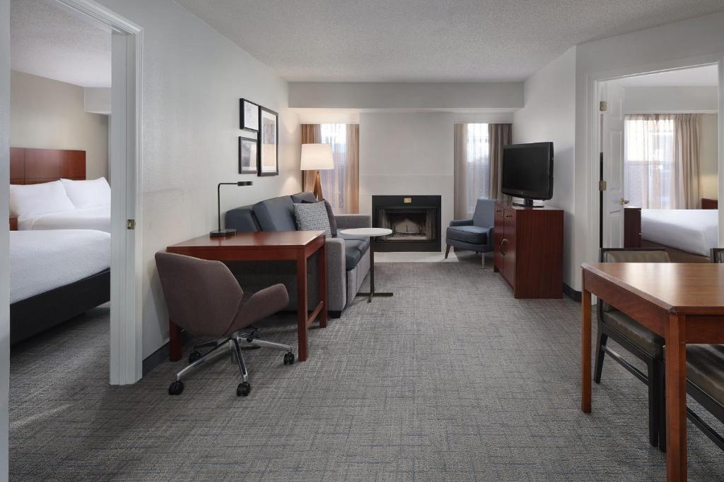 Una habitación de hotel con una cama y un escritorio y una habitación. en Residence Inn Pinehurst Southern Pines, en Southern Pines
