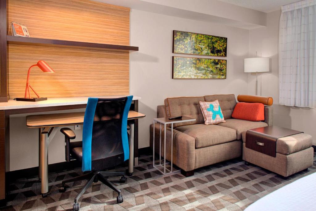Habitación con escritorio, sofá y silla. en TownePlace Suites by Marriott Parkersburg, en Parkersburg