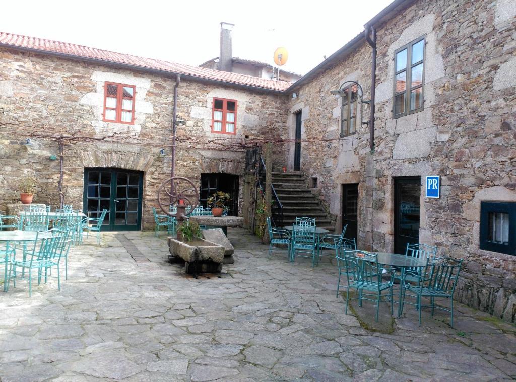 un patio con mesas y sillas en un edificio de piedra en PR San Nicolás, en Santiago de Compostela