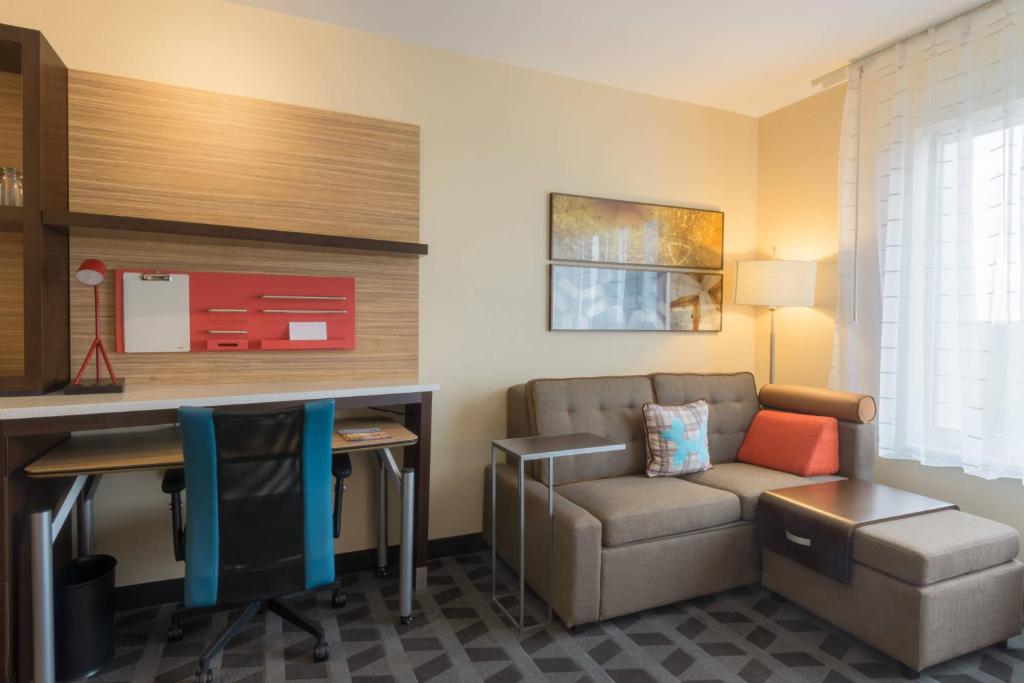 TownePlace Suites by Marriott Syracuse Clay في ليفربول: غرفة معيشة مع أريكة ومكتب