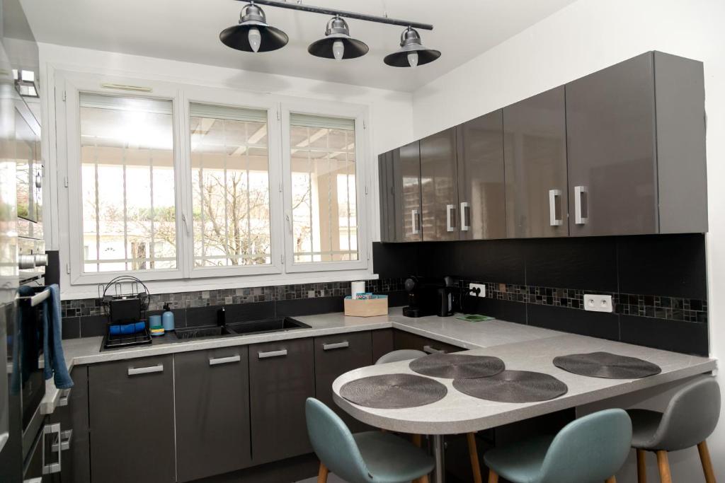 a kitchen with a table and chairs in it at Cosyhome T2 proche Gare entre Paris et Disneyland - Familial Rénové 65 m2 in Gagny