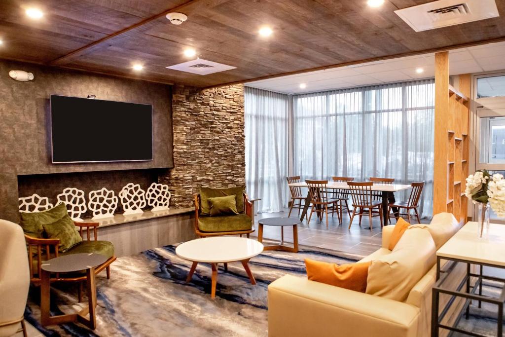 a living room with a tv and a dining room at Fairfield Inn & Suites by Marriott Richmond Airport in Sandston