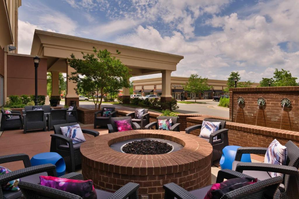 a patio with chairs and a fire pit in front of a building at SpringHill Suites Durham Chapel Hill in Durham