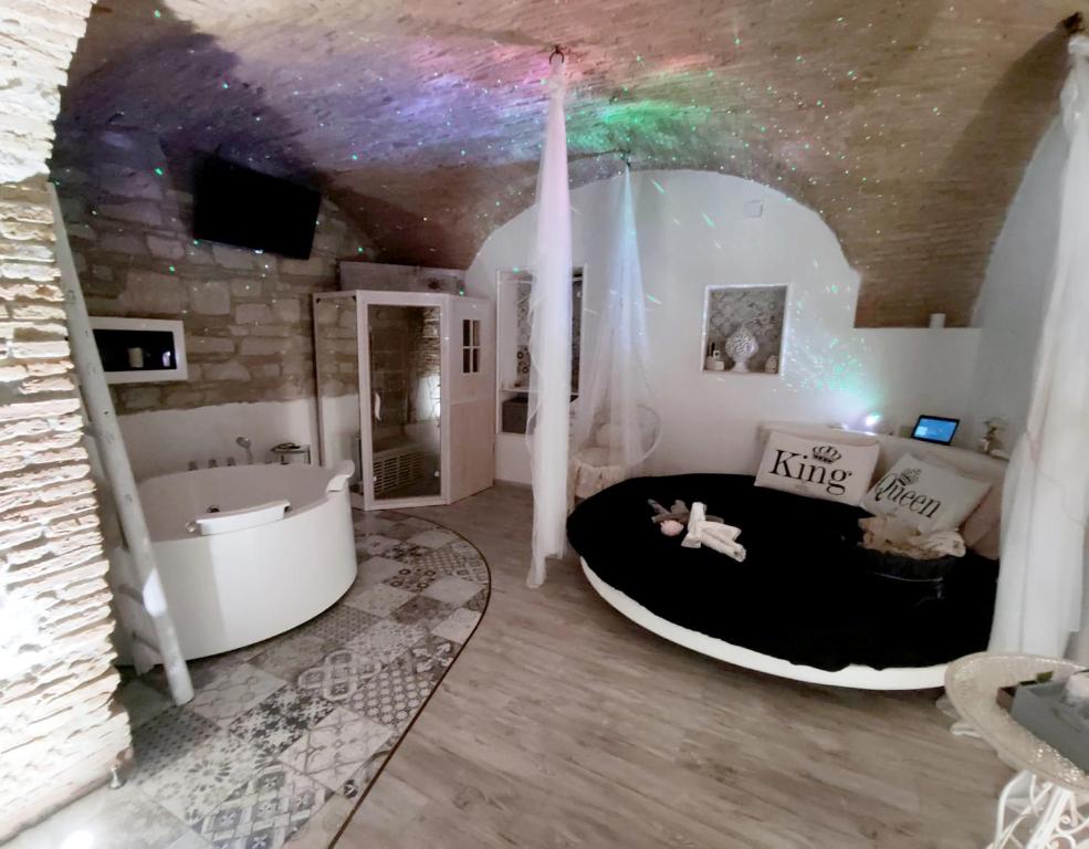 Cette chambre comprend un lit et une baignoire. dans l'établissement VenuSuite VENOSA - Luxury House, Spa & Relax -, à Venosa