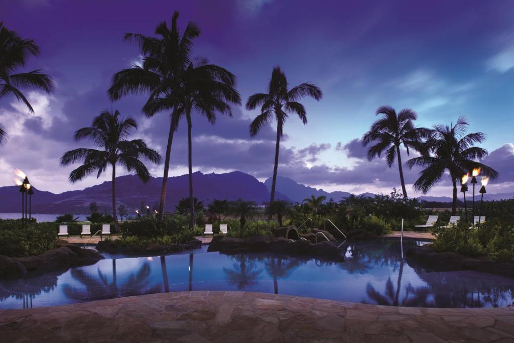 a view of a resort pool with palm trees at Marriott's Kauai Lagoons - Kalanipu'u in Lihue