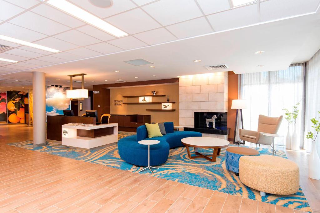 Fairfield Inn & Suites by Marriott Tampa Westshore/Airport في تامبا: لوبي كنب ازرق وطاولة وكراسي