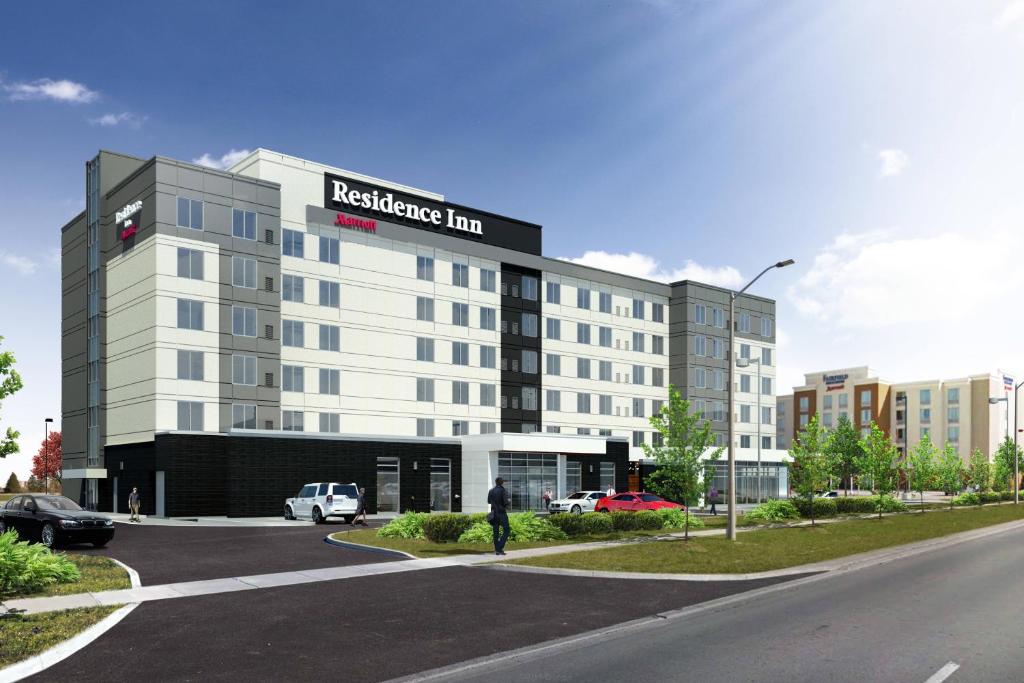 a man is standing in front of a building at Residence Inn by Marriott Toronto Mississauga West in Mississauga