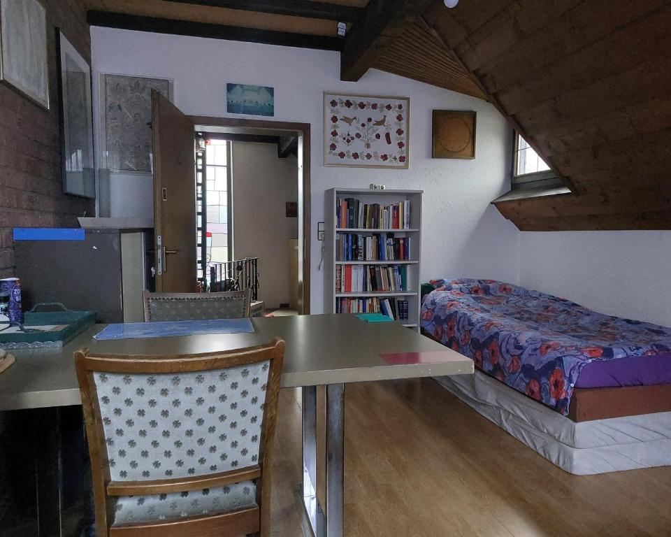 ein Schlafzimmer mit einem Tisch, einem Bett und einem Bücherregal in der Unterkunft Zimmer im Landhaus in Erkelenz