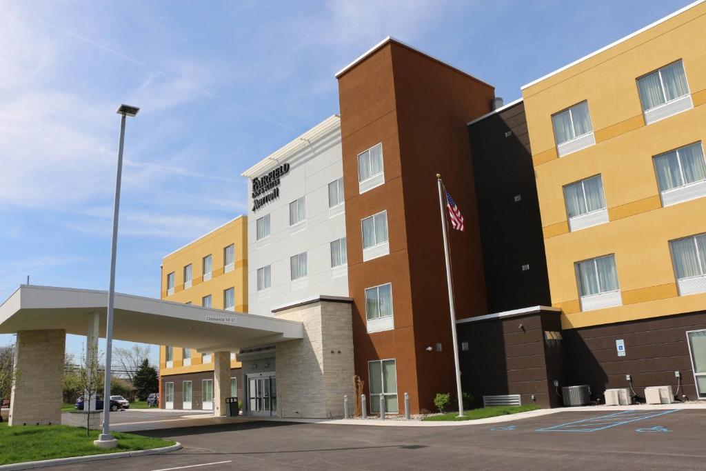 a hotel building with an american flag in front of it at Fairfield Inn & Suites by Marriott Bowling Green in Bowling Green