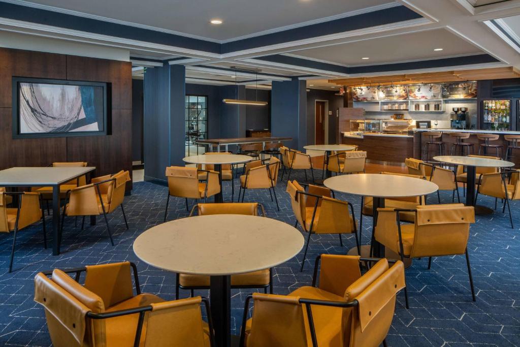 a restaurant with tables and chairs and a bar at Courtyard by Marriott Covington / Mandeville in Covington