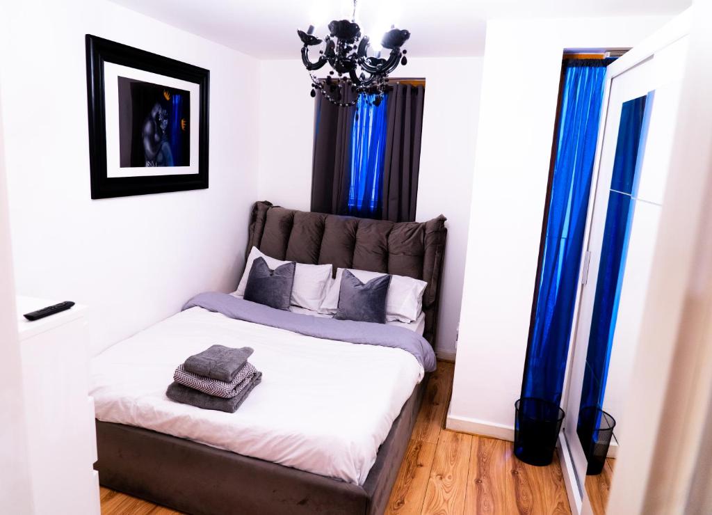 a bedroom with a bed with blue curtains at Lovely 1-Bed Apartment in Hackney London in London