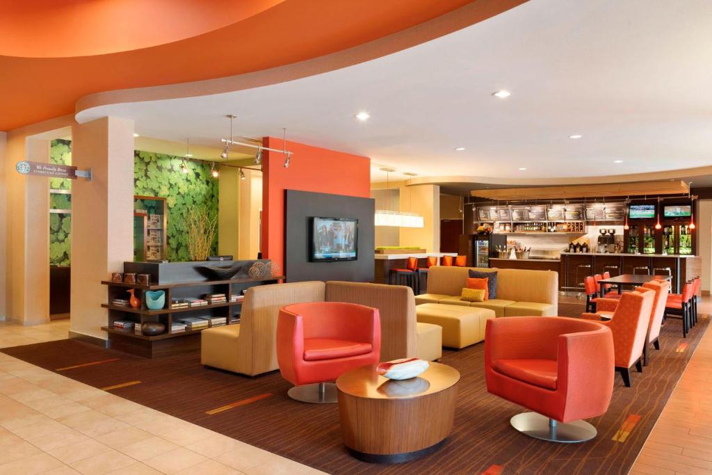 a lobby with couches and chairs and a bar at Courtyard by Marriott Peoria in Peoria