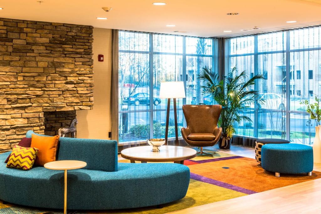 een lobby met blauwe meubels en een stenen muur bij Fairfield Inn & Suites by Marriott Mobile Saraland in Saraland