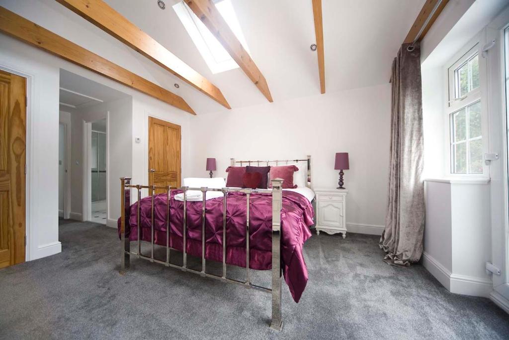 a bedroom with a bed with a purple blanket at Wolviston Cottage in Wolviston