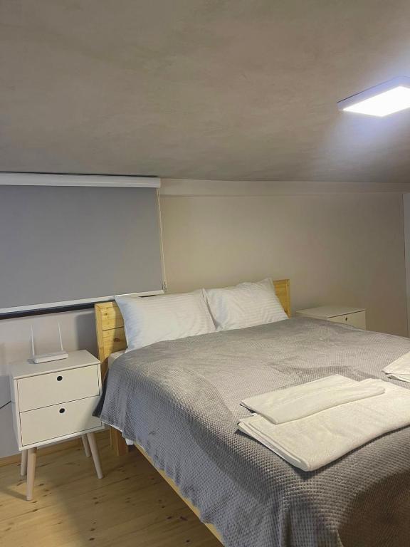 1 dormitorio con 1 cama grande y mesita de noche en Guest House Dashi, en Gjirokastra