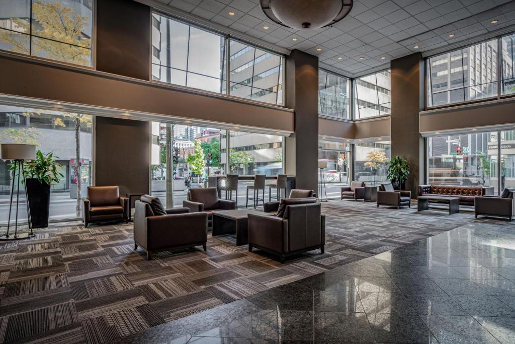 a lobby with chairs and tables in a building at Delta Hotels by Marriott Montreal in Montréal