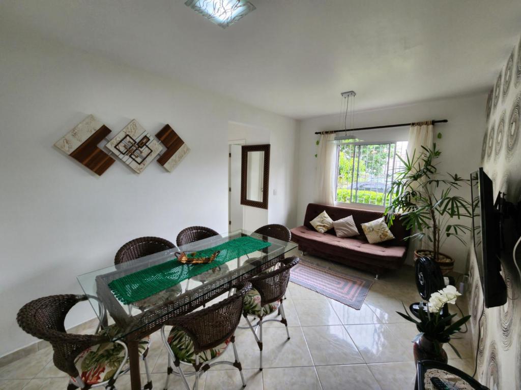 uma sala de estar com uma mesa de vidro e cadeiras em Apartamento em Florianópolis