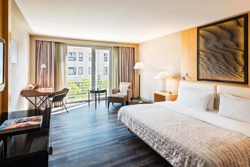 a hotel room with a bed and a desk at Le Méridien Munich in Munich