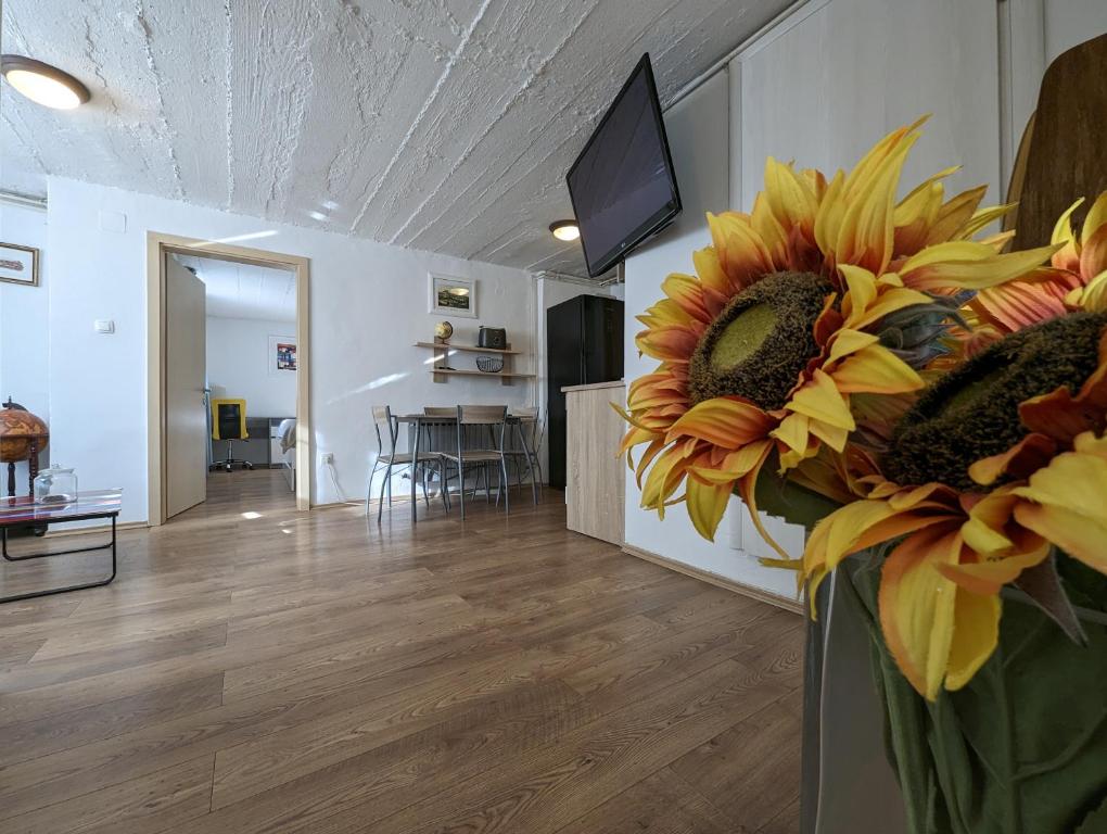 una sala de estar con un jarrón lleno de girasoles en Twin-Magnolias Condo with Garden, Parking & EV Station en Zagreb