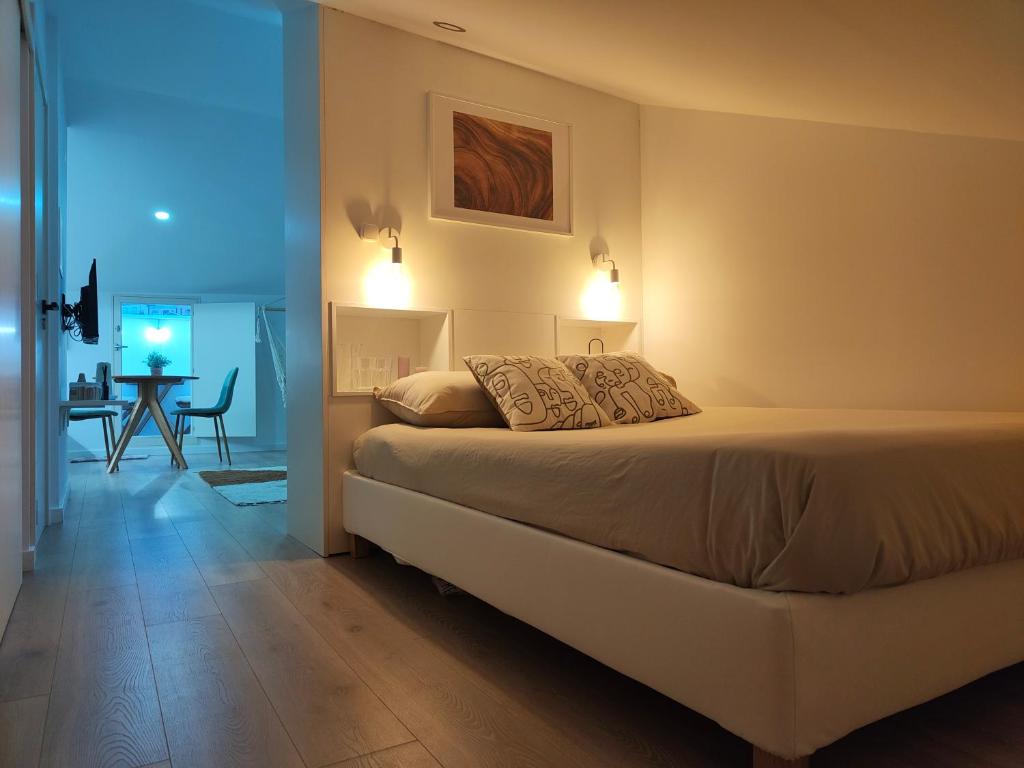 a bedroom with a bed with lights on the wall at Wood Essence Apartment - Cozy Balcony in Coimbra